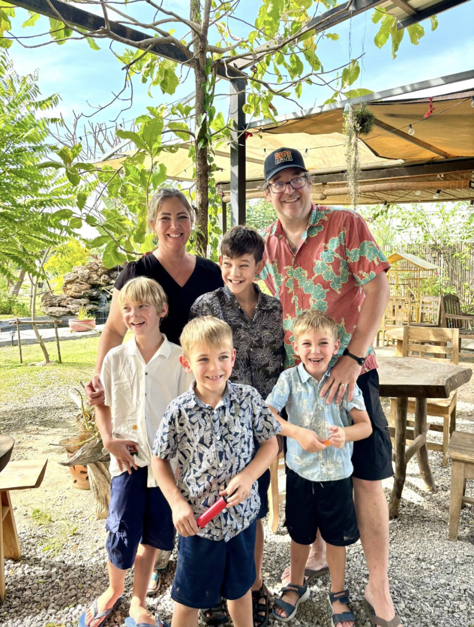 Sabrina, her husband, and their four boys together on a family trip
